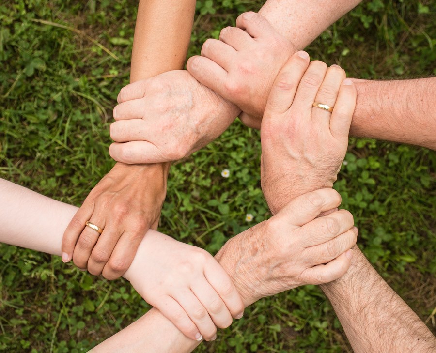 circle of hands holding onto another person's wrist