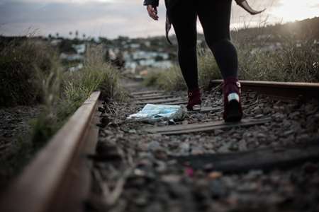 A person walking along railroad tracks.